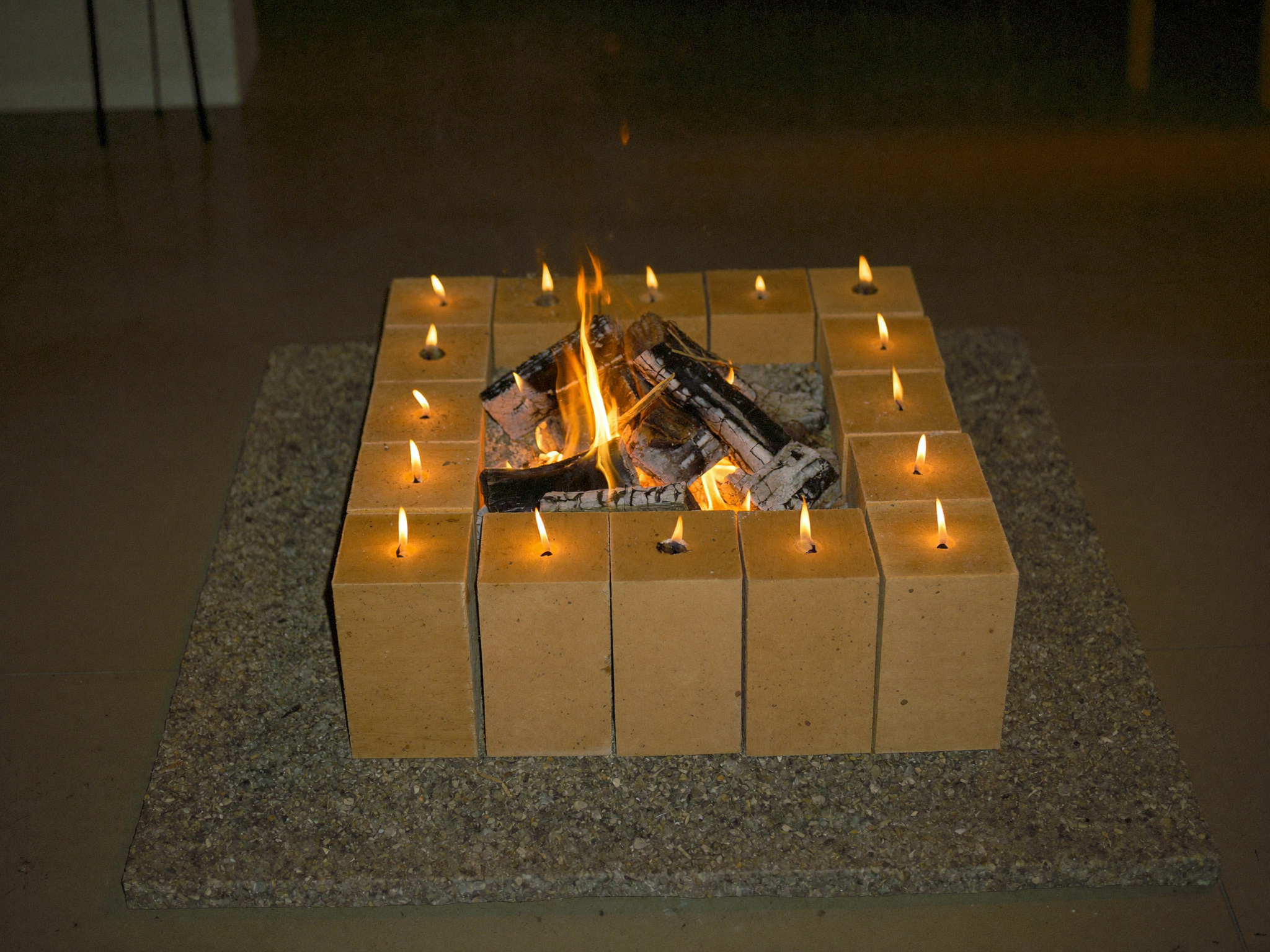 Friends gathered around a finished cinder block fire pit at night