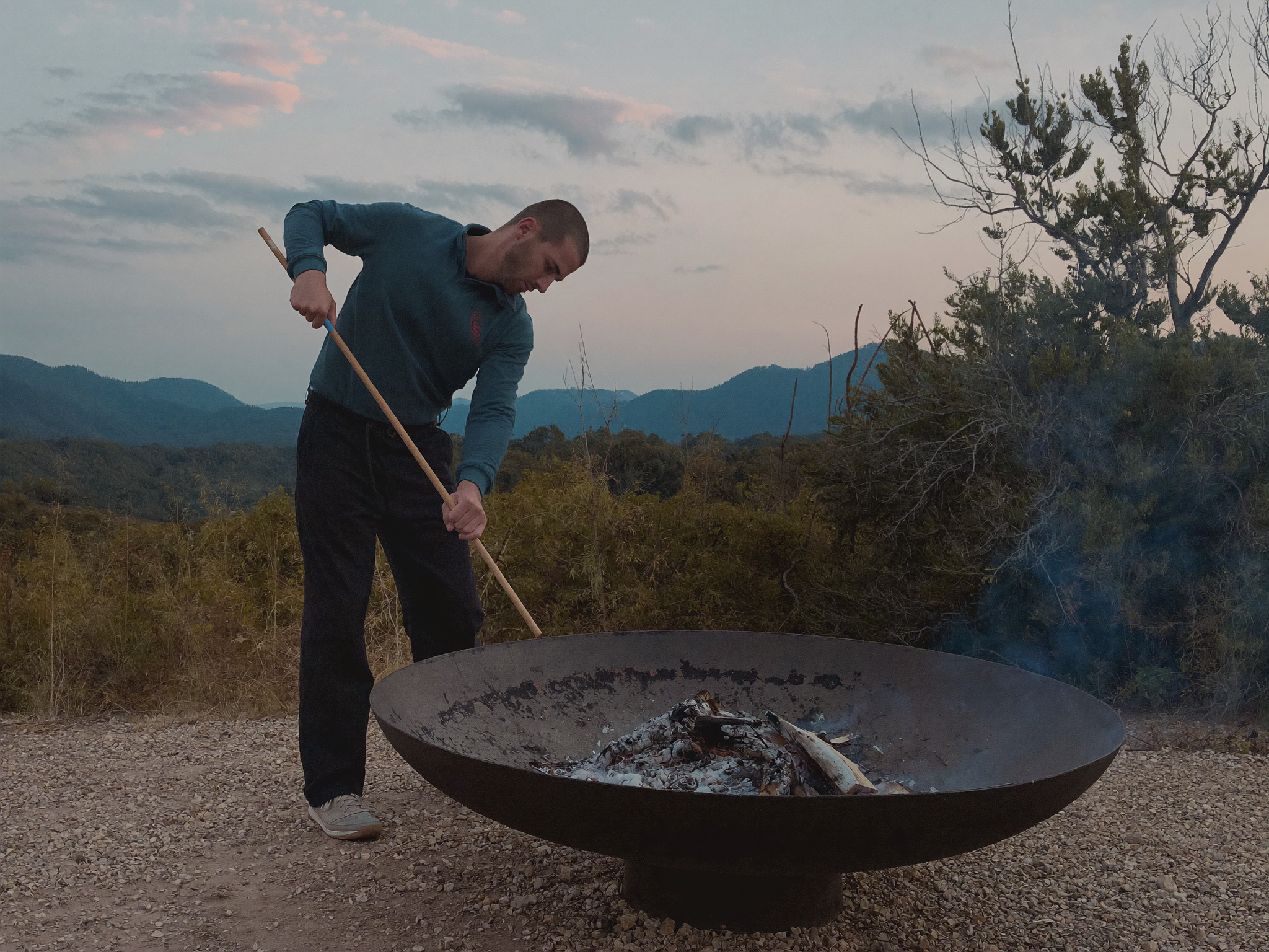 Cleaning a fire pit bowl with a cloth after ash removal