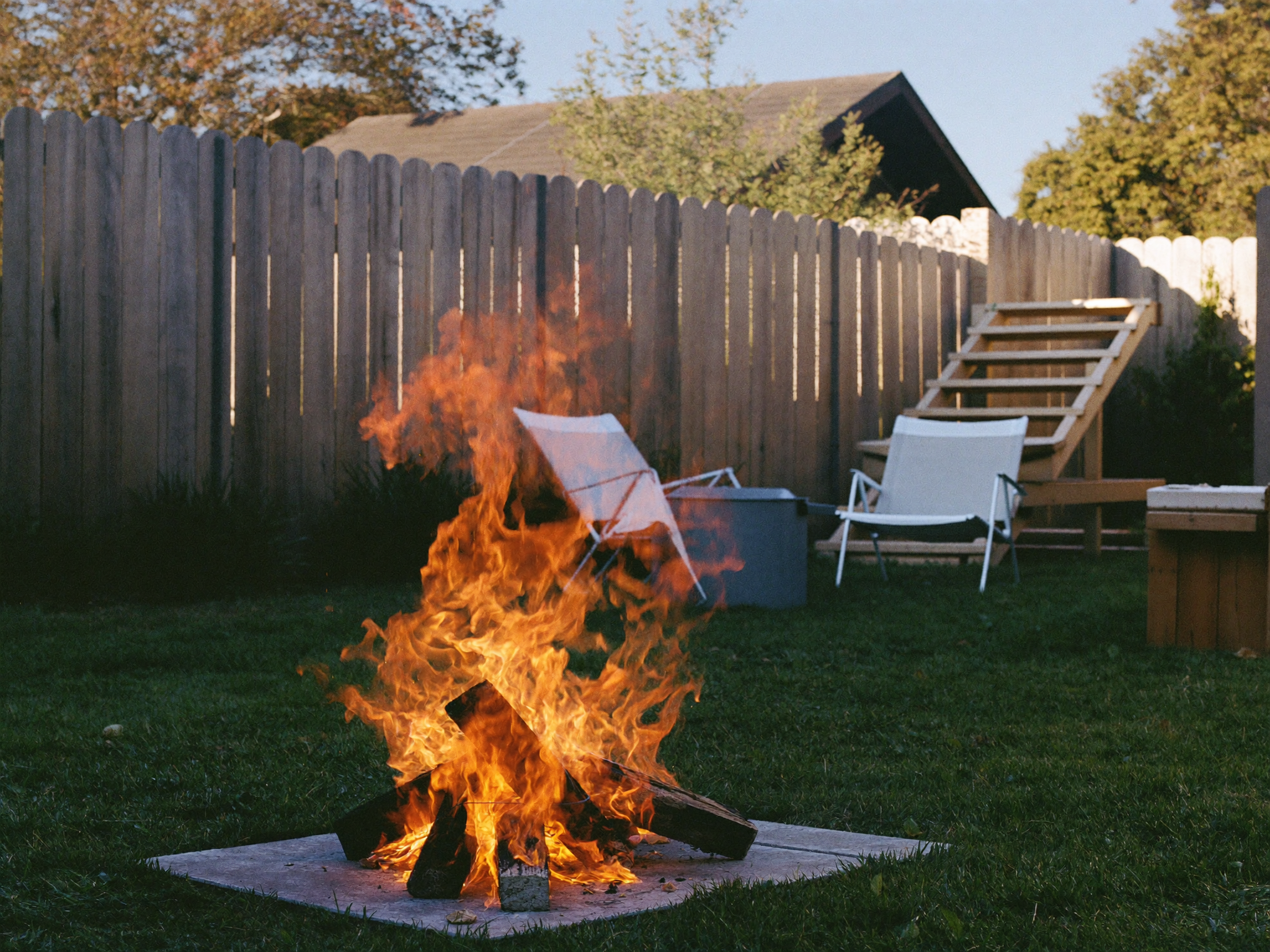 Lighting the tinder at the top of a stacked fire pit lay