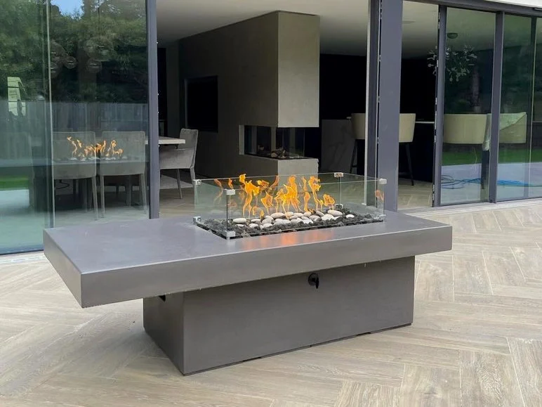 An open side door of a modern propane fire pit table showing a standard 20-pound propane cylinder sitting in a pull-out slide tray.