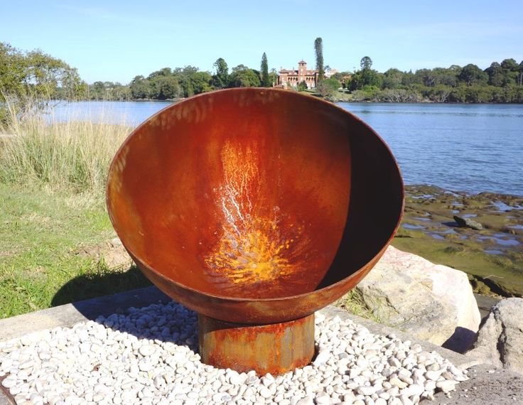 A close-up of orange rust flakes building up along the welded seam of a cheap steel fire pit bowl, showing structural degradation.
