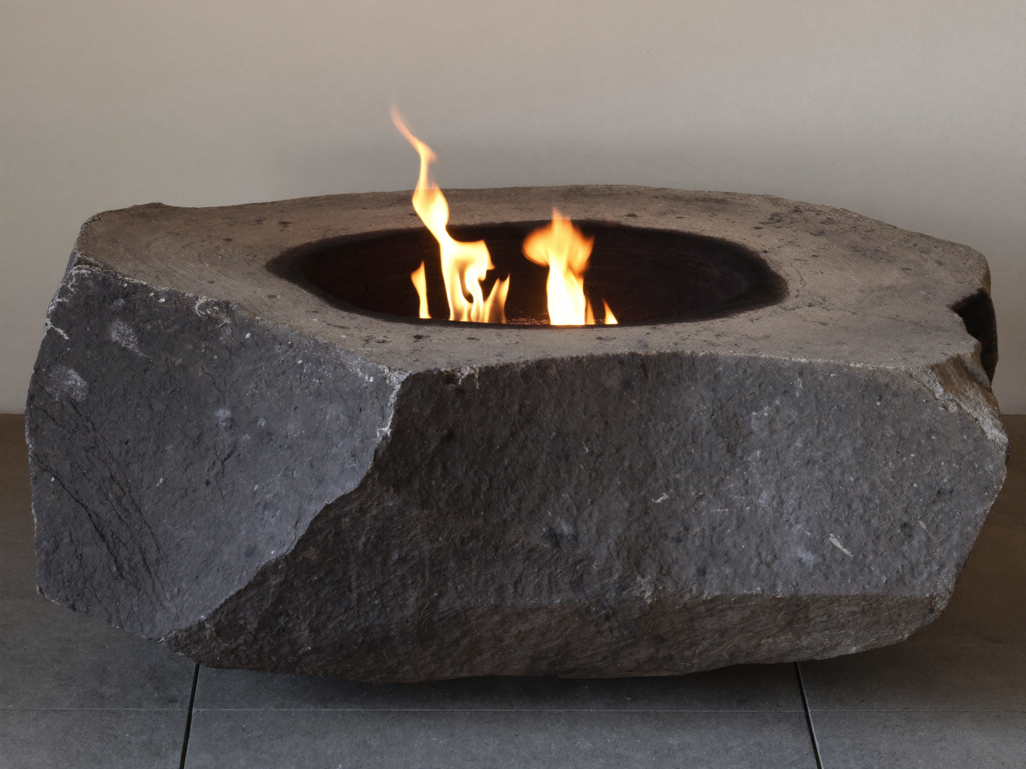 A comparison of acceptable fire pit fuel, seasoned split wood, next to materials that do not belong in a fire pit, including cardboard and treated lumber.